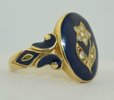 This ring is of the Victorian era, it is dated 1858. The ring is crafted from solid 18K yellow gold with a rich blue enamel. The enamel is in remarkably good condition on the shoulders as well as the face. The enamel surrounds a hand etched flower in yellow gold. The flower features 12 rose cut diamonds. The diamonds make up the composition of the flower. They are all bead prong set. The shoulders of this ring feature the same rich blue enamel. The inside is inscribed, I believe this was a memor Ring Inspo, Memorial Ring, Sparkly Things, Floral Ring, Silver Dragon, Dream Ring, Treasure Chest, Rose Cut Diamond, Sapphire Diamond