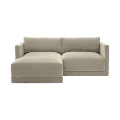 a large gray couch sitting on top of a white floor next to a small ottoman