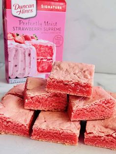 strawberry shortbreads stacked on top of each other next to a carton of frosting