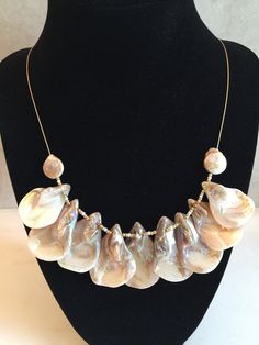 Reversible Ivory/Beige Teardrop Shell Necklace on 18 inch Satin Hamilton gold plated .8mm chain ~ SW117L This hand-crafted necklace features nine (9) iridescent ivory/beige teardrop shells measuring approximately 1" wide by 1-1/4 to 1-1/2" high, divided by gold and iridescent ivory seed beads strung on a delicate .8mm satin hamilton gold plated beading chain and finished with small coin-shaped freshwater pearl beads and a lobster claw clasp.   This necklace is REVERSIBLE!  I prefer wearing the necklace showing the textured organic inside of the shells, with the smooth back against the body.  But, you decide!   Wear this necklace alone, or pair it with one of my bead necklaces and bracelets that I will be listing.  (I have it pictured above with my Mother of Pearl choker necklace MP121L, wh Handmade Mother Of Pearl Necklace For Anniversary, Handmade Pearl Necklace With Briolette Shape, Yellow Gold Teardrop Necklace With Pearl Pendant, Handmade Gold Pearl Necklace With Briolette, Handmade Briolette Necklace For Anniversary, Gold Teardrop Pearl Drop Necklace, Pearl Drop Teardrop Necklace For Anniversary, Anniversary Teardrop Pearl Drop Necklace, Gold Single Strand Mother Of Pearl Jewelry