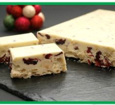 two pieces of cheese sitting on top of a black slate counter next to christmas decorations