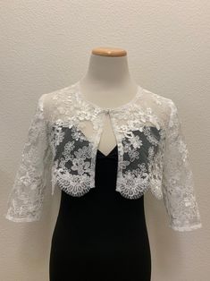 White or Black floral lace wedding handmade bolero. Bridal and evening lace long sleeves jacket. Scalloped edgings and sleeves shrug. Corded Sequined Lace Bolero.    This elegant handmade design has a pretty scalloped lace edge all the way around and on the long-length sleeves. A small hook closure finishes it off at the neckline to allow movement and to show your dress or top underneath. The hand-made pearl brooch covering the hook closure gives a more luxurious and stylish look.  Sizes  S - M Long Sleeve White Lace Top For Wedding, White Long Sleeve Lace Top For Wedding, Elegant Spring Wedding Lace, Spring Wedding Elegant Lace, Fitted Lace For Mother Of The Bride, Long Sleeve Lace Top For Spring Wedding, Lace Top With Long Sleeves For Wedding, Spring Wedding Long Sleeve Lace Top, Evening Shrug With Lace Trim