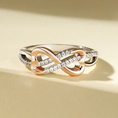 Embrace the intertwining beauty of love and elegance with our sterling silver ring. The open heart and twisted knot design symbolize a bond that is strong, yet tender. The rose gold heart adds a touch of warmth and romance to this exquisite piece. Let this ring grace your hand as a reminder of the intertwining paths of love and connection. The intricate design speaks to the complexity and beauty of relationships, while the heart symbolizes the depth of emotion and affection shared between souls. Wear this sterling silver ring as a symbol of enduring love and unity, a testament to the intertwining of hearts and the strength found in togetherness.Carat Weight: 0.3 ctStone Size: 1 mmStone Type: Jeulia® StoneNumber of Stones: 30 Stone Color: Diamond WhiteStone Shape: RoundWeight: 3.1 gWidth: 1 Elegant Rose Gold Promise Heart Ring, Elegant Rose Gold Heart Promise Ring, Elegant Rose Gold Heart Ring, Elegant Rose Gold Rings For Valentine's Day, Elegant Rose Gold Heart Ring As Gift, Elegant Rose Gold Heart Ring For Mother's Day, Elegant Double Heart Ring For Mother's Day, Elegant Double Heart Ring, Elegant Rose Gold Heart Ring Gift