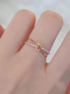 a woman's hand with a gold ring on it and diamonds in the middle