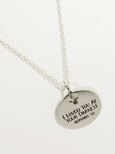 "This silver necklace is a simple but beautiful encouragement gift. The stainless steel laser engraved pendant has \"I loved you at your darkest\" from Romans 5:8 on it. This necklace is available on a silver plated chain in your choice of 16, 18, 20, 22, 24, 26, 28 or 30 iInches. The pendant is also available for separate purchase if you have another necklace on which you would like to wear it. Each item comes individually boxed and ready to give as a gift. This jewelry item has small parts and Inspirational Silver Necklace For Father's Day, Silver Necklace With Hallmark For Best Friend Gift, Inspirational Silver Stainless Steel Necklaces, Inspirational Silver Stainless Steel Necklace, Meaningful Silver Stainless Steel Necklace, Father Son Gifts, Bible Verse Jewelry, Scripture Jewelry, Hamsa Earrings