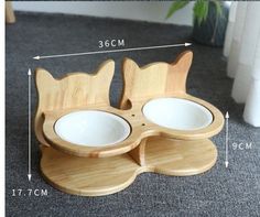 the wooden cat dish holder has two bowls in it