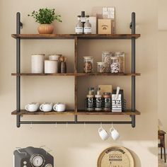 a shelf with coffee cups and other items on it next to a wall mounted clock