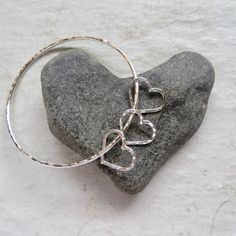 "Sterling Silver Heart Charm Bangle~ Beautiful sterling silver bangle with your choice of hearts, add a heart for each child or grandchild for a personalized gift for the special women in your life! *This listing is for a sterling silver hammered bangle with your choice of hearts.* Made with thick 12 g. sterling silver thicker than 14g. NO RETUNS on CUSTOM orders Please view the last picture on this listing that shows how to measure for your correct size as there will be a charge for size exchan Nickel Free Heart Bracelet For Anniversary On Valentine's Day, Nickel Free Heart Bracelet For Anniversary, Silver Heart Bracelets For Anniversary Gift, Silver Heart Bracelet For Anniversary, Silver Heart Bracelets For Anniversary, Sterling Silver Bracelet With Heart Charm For Anniversary, Sterling Silver Bracelets With Heart Charm For Anniversary, Sterling Silver Heart Bracelet For Wedding, Silver Heart Bracelet For Anniversary Gift