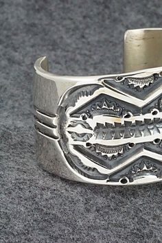 This stunning sterling silver bracelet was made by Navajo silversmith Jerrold Tahe. The inside is signed J. Tahe and stamped sterling.Size: 6" (will fit up to a 7 1/2" wrist)Gap: 1 1/2"Width: 1 1/2"Free shipping on all orders! We ship with USPS and always include tracking. All orders ship within a day of payment.Returns are accepted up to 30 days after you receive your order. Just send us a message. Our shop offers cash back or store credit. The item must be returned in new condition. Southwestern Sterling Silver Polished Bangle Bracelet, Southwestern Sterling Silver Bangle With Polished Finish, Southwestern Polished Sterling Silver Bangle, Southwestern Stamped 925 Cuff Bangle Bracelet, Unique Polished Sterling Silver Bracelet, Artisan Sterling Silver Bracelet With Etched Details, Artisan Silver Bracelet With Stamped Details, Artisan Engraved Sterling Silver Bracelet, Southwestern Style Polished Bangle