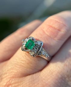 Elevate your jewelry collection with this very unique Vintage Emerald and Diamond Art Deco Style Ring--an exquisite fusion of timeless elegance and Art Deco glamour. This ring is a testament to the opulence of a bygone era, featuring a lush emerald at its center, surrounded by a dazzling array of diamonds, all set in a meticulously crafted Art Deco-inspired design.  Natural emerald weighing .44 carats Natural Diamonds weighing .15 carats.  Size: 6.5 The emerald, with its rich green hue, is a cap Timeless Emerald Diamond Wedding Ring, Timeless Emerald Anniversary Ring, Timeless Emerald Wedding Anniversary Ring, Luxury Diamond-cut Emerald Ring For Formal Occasions, Fine Jewelry Asscher Cut For Formal Occasions, Luxury Emerald Ring With Diamond Cut For Formal Events, Luxury Emerald Ring With Diamond Cut For Formal Occasions, Emerald Cluster Ring With Diamond Accents For Gifts, Emerald Asscher Cut Diamond Ring For Anniversary