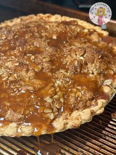 an uncooked pie sitting on top of a bbq grill covered in caramel sauce