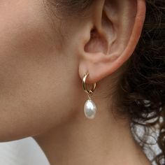 Gorgeous sterling silver-hinged hoop earrings with a single large baroque pearl suspended below. Easily worn for work, for play, for the day, or into the night. Made with high quality and durable hinged clasp. Sia adds an edge to your style. Also available in 14k gold filled.  All Kiri & Belle pieces are carefully handmade in the UK using the highest quality materials. Celebrating the unique and organic beauty of baroque pearls. A free Kiri & Belle polishing cloth and a storage pouch are provided with every order. The polishing cloth will remove tarnish from silver and gold. It is impregnated with an anti-tarnish agent to give a lasting shine. It should not be used on pearls.  We lovingly handcraft our jewellery in sterling silver and gold-filled, with freshwater pearls. Gold filled is a t Gold Bridesmaid Necklace, Small Pearl Necklace, Small Pearl Earrings, Chunky Pearl Necklace, Pink Pearl Earrings, Large Pearl Earrings, Silver Bridal Earrings, Black Pearl Earrings, Long Pearl Earrings