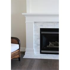 a white fireplace with a wicker chair next to it