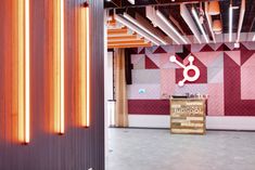 the interior of an office building with pink and purple wallpaper, wooden beams, and neon lights