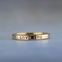 Show her how you feel with this sweet little gold ring.  "I LOVE YOU" is inscribed on this outside of the solid 14k gold ring. It has a smooth finish for a lovely shine.  This ring is ready to ship in a size 5.  If you need a different size, I am happy to make a ring exactly to your specifications. You can find the made to order version of this ring here https://www.etsy.com/listing/99515676.  High quality 1 mm stamps were used to stamp the tiny but readable words on the ring. To see how small the letters are, take a look at a penny. The words "In God we Trust" are the same size. -------------------- About the ring - Handmade from 14k yellow gold. - 2 mm wide (5/64 of an inch) wide - Smooth shiny finish - Inscription outside: I LOVE YOU -------------------- The ring will arrive gift wrappe I Love You Ring, Paper Ring, A Penny, In God We Trust, 14k Gold Ring, Ring Handmade, Ring Box, Handmade Ring, Gold Ring