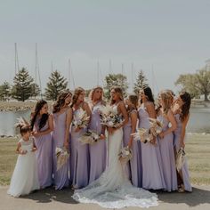 a group of women standing next to each other in front of a body of water