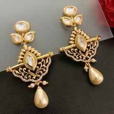 Fashionable and stylish, this pair of 18K Gold Plated Kundan Earrings will make you shine and stand out. This color works well with a variety of outfits. You can wear them with traditional outfits, western outfits, indo-western outfits, or casual gatherings. Best for gifting or for personal use, wear it to any occasion and be the spotlight. Eye-catching and unique jewelry that will set you apart. Gift this piece to a loved one, and see their face light up with joy. Length ~ 5 cm Traditional Drop Clip-on Earrings For Party, Traditional Elegant Earrings For Festivals, Traditional Elegant Danglers For Celebration, Traditional Danglers For Celebration With Elegant Design, Traditional Bridal Earrings With Elegant Design, Traditional Bridal Earrings With Elegant Design For Festivals, Traditional Elegant Bridal Earrings For Festivals, Heavy Gold Earrings For Festive Occasion, Elegant Plug Earrings For Festive Celebration