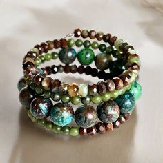 Shades of green, blue, and brown dominate this beaded coil wrap bracelet. Faceted chrysoprase, round jade, and African turquoise come together in a medley of tone and texture in this done-for-you stack. I love the earth tones and contrast of size, color, and texture in this one-of-a-kind bracelet. 4mm round jade 4x5mm faceted chrysoprase 10mm African turqouise one size fits most - best for small to medium wrists Handmade in Lincoln, Nebraska Turquoise Wrap Bracelet, Lincoln Nebraska, Love The Earth, African Turquoise, Blue And Brown, Earth Tones, Earring Necklace, Nebraska, Ring Necklace