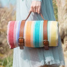 a woman carrying a multicolored striped bag