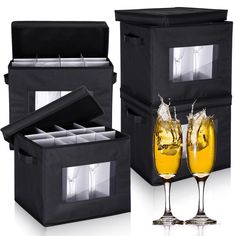 two glasses of champagne are next to a black storage box and an empty glass case