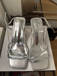 Never worn silver heels. Heel height: 5.5cm/2.1" size 8. Runs big Metallic Silver High Heels For Summer, Silver Heels With Stacked Heel And Round Toe, Silver High Heels Of Medium Width, Metallic Heels With Stacked Heel, Silver High Heels With Medium Width, Silver High Heel Shoes With Medium Width, Metallic Silver Heels With Ankle And Heel Straps, Silver Kitten Heels With Heel Strap For Summer, Silver Medium Width High Heels