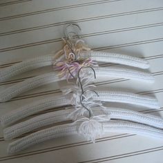 four white pieces of rope with flowers attached to them