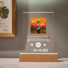 an audio player is placed on top of a wooden stand next to a framed photo