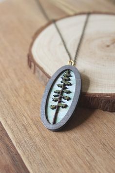 Welcome to our enchanting collection of wooden laser engraved diorama necklaces! Embrace your inner witchy vibes with these magical pieces featuring intricate designs of mushrooms, ferns, trees, and mini magic scenes. Each lightweight necklace is hand painted with care and comes on a beautiful brass chain. - Hand painted wood pieces add a unique touch to each necklace - Mini landscape scenes create a whimsical feel - Brass or gold chain adds a touch of elegance - Water resistant for everyday wea Nature-inspired Pendant Necklace With Etched Details, Gift Etched Necklaces, Nickel-free Nature-inspired Jewelry With Round Pendant, Nature-inspired Nickel-free Jewelry With Round Pendant, Nature-inspired Engraved Round Pendant Necklace, Nature-inspired Engraved Jewelry For Jewelry Making, Electroformed Brass Necklace As A Gift, Engraved Nature-inspired Jewelry For Jewelry Making, Unique Etched Round Pendant Necklace