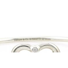 Material: sterling silver Hallmark: Tiffany & Co. Peretti 925 Spain Measurement: inner circumference: 6.5" x 0.10" thick Heart: 0.77" tall x 0.84" wide x 0.16" thick Weight: 13.4 grams  This authentic bangle is from Tiffany & Co. by designer Elsa Peretti from her Open Heart collection. It is crafted from sterling silver with a 2.5mm thick wire bangle, the front has the contour open heart with a 2 points diamond at the top of the heart. One end of the bangle has a small curved hook which and secu Luxury Sterling Silver Heart Bracelet For Gift, Luxury Sterling Silver Heart Bracelet For Anniversary, Luxury Sterling Silver Bracelets For Valentine's Day, Luxury Silver Bracelets For Valentine's Day, Luxury Sterling Silver Heart Bracelet For Valentine's Day, Classic Bracelets For Anniversary On Valentine's Day, Elegant Silver Heart Chain Bracelet, Classic Bracelets For Valentine's Day, Classic Bracelets For Valentine's Day Formal Occasion