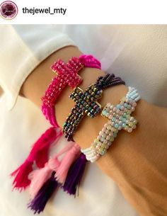 three bracelets with beads and tassels on the wrist, one in pink, one in purple