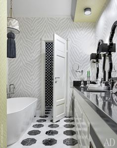 the bathroom is decorated with black and white wallpaper, flooring, and accessories