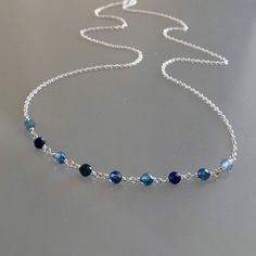 Genuine, premium-quality, shaded Kanchanaburi blue sapphire beaded choker/necklace, wire-wrapped in sterling silver This dainty and elegant choker/necklace is designed with genuine, 3.5 mm, micro-faceted ombré Kanchanaburi blue sapphire gemstones wire-wrapped to form a chain of linked gemstones as the frontal segment, measuring 2.5 inches and linked to a dainty but sturdy sterling silver chain. These gemstones are finely-faceted, highly polished and; while tiny, reflect light beautifully.  This Cheap Blue Jewelry With Silver Beads, Cheap Blue Adjustable Chain Necklace, Cheap Blue Chain Necklace With Adjustable Chain, Cheap Blue Beaded Chain Necklace, Cheap Blue Jewelry With Silver Chain, Cheap Blue Jewelry With Natural Stones, Affordable Blue Metal Chain Necklace, Cheap Handmade Blue Jewelry, Cheap Blue Beaded Necklace For Gifting