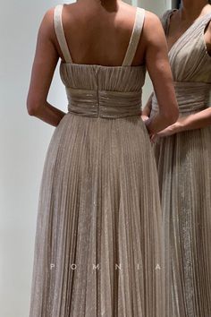 two women in long dresses looking at each other's back and shoulder length mirrors behind them