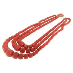 This striking necklace features multiple strands of richly hued Sardinian coral, known for its vivid color and prized throughout history for its natural beauty. The coral beads are meticulously shaped and polished, creating a luxurious cascade of warm, inviting red that lays gracefully upon the collarbone. Each strand varies subtly in the size of its beads, adding depth and texture to the design. The clasp is crafted from 9-karat yellow gold, providing a secure fastening and a gleaming contrast Traditional Multi-strand Red Coral Necklace, Traditional Multi-strand Red Coral Necklaces, Traditional Coral Single Strand Necklace, Traditional Multi-strand Red Coral Beaded Necklace, Multi-strand Red Coral Necklace With Polished Beads, Traditional Single Strand Coral Jewelry, Coral Multi-strand Necklace As Gift, Coral Multi-strand Necklace For Gift, Multi-strand Coral Necklace For Gift