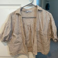 Never Worn! No Damage Or Stains. 100% Linen Tan Short Sleeve Button Up Crop Shirt. Soo Cute Over Bathing Suits! Check My Listings I Have This In White As Well! Cheap Faded Stonewashed Tops, Casual Beige Tops With Snap Buttons, Collared Beige Tops With Snap Buttons, Beige Collared Tops With Snap Buttons, Beige Relaxed Fit Top With Buttons, Everyday Beige Shirt With Buttons, Casual Brown Top With Buttoned Pockets, Khaki Button-up Tops With Buttoned Pockets, Casual Beige Blouse With Buttons