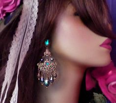 "These Victorian Filigree Chandelier Earrings are made with *Peacock Teal crystal and ornate layered brass filigrees. A Swarovski rhinestone decorates the surface of the filigrees for an added sparkle! Available with Posts, Clip-Ons or French Wires. The pictures show the post version. If french wire are chosen this top Aqua stone will be omitted from the design. -3 1/2\" Long x 1 3/8\" Wide -0.3 oz. ea. -Free Ship! (Domestic) -Many Colors Available! *Comes Ready To Gift in Decorative Packaging * Turquoise Bohemian Chandelier Earrings For Party, Bohemian Turquoise Chandelier Earrings For Party, Bohemian Jeweled Dangle Chandelier Earrings, Bohemian Jeweled Chandelier Earrings As Gift, Bohemian Green Chandelier Earrings For Wedding, Bohemian Pierced Chandelier Earrings For Wedding, Bohemian Chandelier Earrings With Filigree For Parties, Peacock Teal, Victorian Filigree