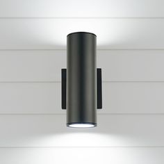 a black wall mounted light on the side of a white building with wood paneling