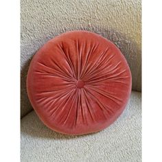 a red round cushion on the back of a couch