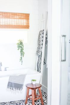 a white bath tub sitting next to a wooden stool