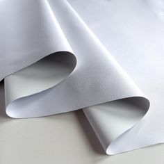 two white sheets of paper folded on top of each other, with the end rolled up