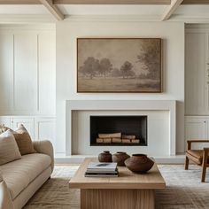 a living room filled with furniture and a painting on the wall over a fire place