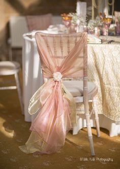 an image of a chair with a bow tied to it's back in front of a table