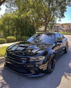 a black dodge charger parked on the street