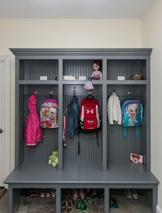 a gray locker with several coats and purses on it