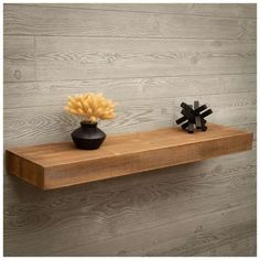 two black vases with yellow flowers on a wooden shelf