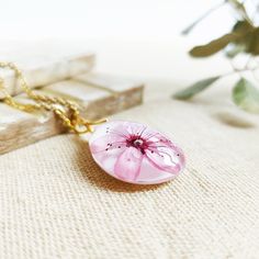 This Cherry blossom necklace is part of my cherry blossom jewelry collection. The sakura flower is highly admired in Japan, so take this sakura flower necklace with you to wear a little piece of this magic beauty. This real flower necklace will never make you go unnoticed because it is really elegant and unique. A cherry blossom necklace to have the Spring always with you... The chain is made of hypoallergenic stainless steel. The resin provides this cherry blossom necklace a perfect crystalline Feminine Flower Pendant Necklace As A Gift, Delicate Flower Necklace For Her, Feminine Flower-shaped Necklaces For Gifts, Elegant Pressed Flower Necklace For Mom, Dainty Pink Pendant Flower Necklace, Dainty Blossom Flower Jewelry, Gift Flower Pendant Necklace With Flower Decoration, Elegant Flower Pendant Necklace With Pressed Flowers, Elegant Necklace With Pressed Flower Pendant