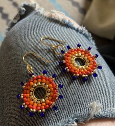 rock these sunburst, custom TSA-approved gold, red-orange, orange and blue handwoven earrings. Vibrant Orange Jewelry For Festival, Vibrant Orange Festival Jewelry, Handmade Vibrant Gold Earrings, Vibrant Handmade Gold Earrings, Handmade Orange Earrings For Everyday, Handmade Orange Everyday Earrings, Handmade Orange Round Jewelry, Everyday Handmade Orange Earrings, Handmade Vibrant Summer Jewelry