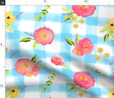 a blue and white checkerboard with pink flowers on it, next to a ruler