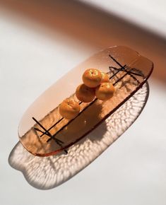 a glass plate with some food in it on top of a white tableclothed surface