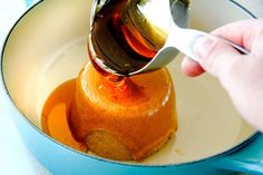 someone is pouring syrup into a cake in a pan